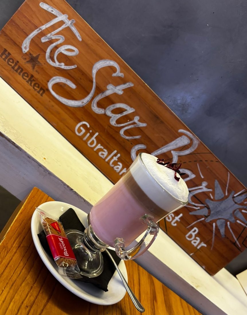 A speciality latte served at The Star Bar, with the bar's wooden sign behind it